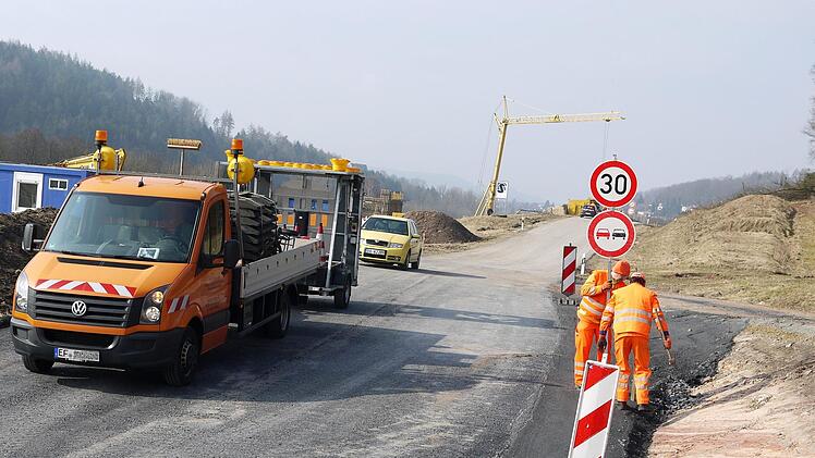 Mitarbeiter einer Fachfirma stellen die Schilder mit der Geschwindigkeitsbegrenzung auf der Baustellenumfahrung zwischen Rödental und Neustadt auf.