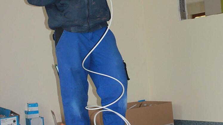 Elektriker Janick Schülein kümmert sich um die Kabel.