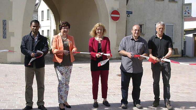 Das Zerschneiden des Bandes symbolisierte die offizielle Freigabe des Teilstücks Kissinger Straße (von links): Pater Sony, Bürgermeisterin Patricia Schießer, Daniela Kircher von der Städtebauförderung, Ingenieur und Bauleiter Markus Schraub und Fa.-Ullrich-Bauleiter Helmut Nies.  Foto: Winfried Ehling