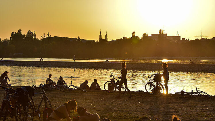 Der Wöhrder See inmitten von Nürnberg: Uferwiese an der Norikusbucht bei Sonnenuntergang.