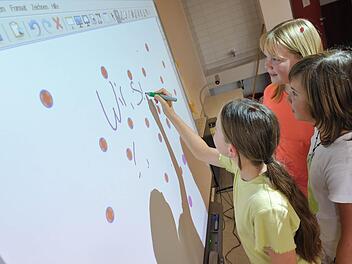 Schülerinnen einer sechsten Klasse an einem "Whiteboard"". Was noch vor kurzem als der letzte Schrei an den Schulen galt, ist schon wieder veraltet.  Foto: Uwe Anspach/dpa