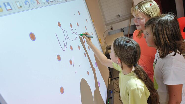 Schülerinnen einer sechsten Klasse an einem "Whiteboard"". Was noch vor kurzem als der letzte Schrei an den Schulen galt, ist schon wieder veraltet.  Foto: Uwe Anspach/dpa