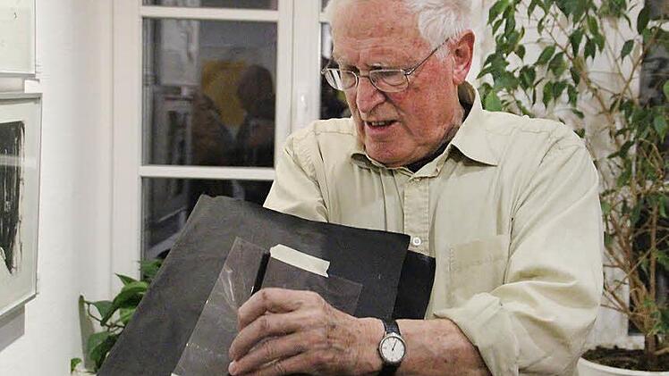 Auf einer Astralon-Platte kratzt Robert Reiter mit einer Metallnadel die Fugen, die mit Farbe aus Leinöl und Eisenoxid per Hand ausgefüllt werden. Danach werden beim Druck die schwarzen Linien auf das Papier gedruckt. Foto: Mariell Dörrschmidt