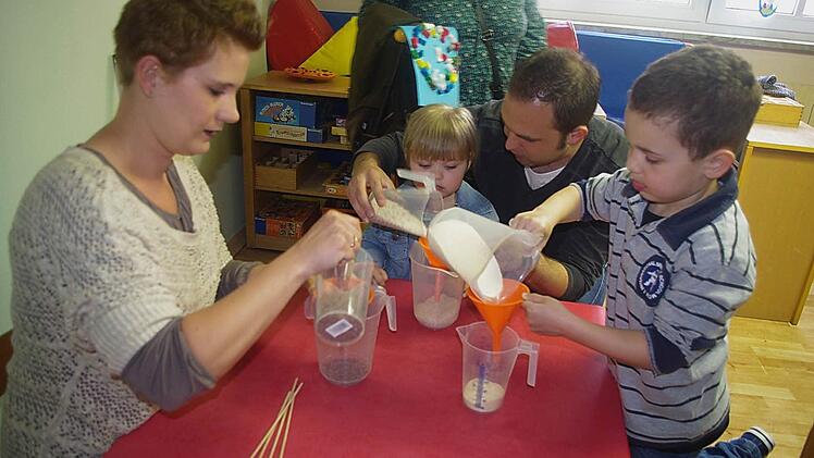 Maja und Jannis testen, welches Material am schnellsten durch welchen Trichter rieselt.