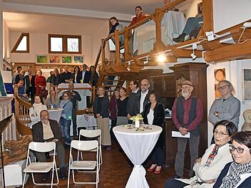 Viele Gäste waren gekommen, um dem Galeristenehepaar Egon Stumpf und Eleonore Schmidts-Stumpf (hinter dem Tisch) zum 20-jährigen Bestehen der Galerie im Saal in Eschenau zu gratulieren.  Foto: Ulrike Langer