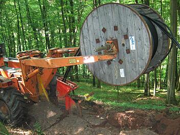 Ein Kabelpflug zieht ein 20 000-Volt-Stromkabel in das Erdreich ein. Foto: Bayernwerk