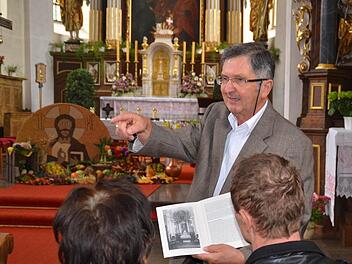 Kirchenpfleger Georg Rottenberger ist bestens mit der Geschichte der Burkardrother Pfarrkirche vertraut. Den Besuchern erklärte er bei einer Kirchenführung am Sonntagnachmittag, wie der Altarraum vor seinem Umbau 1968 aussah. Zudem sprach er von der bevorstehenden Sanierung der Kirche. Foto: Kathrin Kupka-Hahn