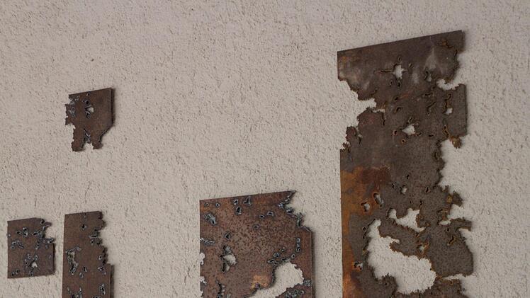 Ausschnitt aus dem Kunstwerk von Hans Doppel aus Haßfurt, das mit korrodierten Eisenplatten auf das "Wachstum und den Zerfall allen irdischen Seins" hinweist.