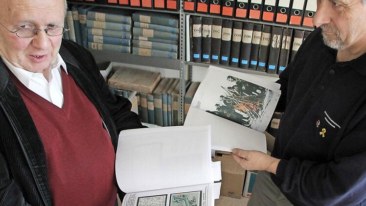 Erich Fries (rechts) übergibt an Klaus-Dieter Guhling zwei Bände seiner geschichtlichen Dokumentationen. Foto: Heike Beudert