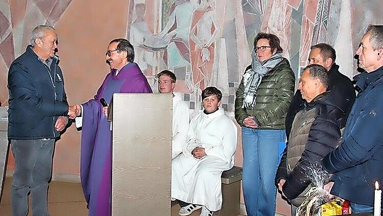 Pfarrer Walter Ries bedankte sich mit einem H&auml;ndedruck bei Heinrich Leicht. Weiter auf dem Bild die Mitglieder der Kirchenverwaltung und Ministranten. Aus den H&auml;nden der Kirchenverwaltung erhielt Heinrich Leicht eine Urkunde und einen Geschenkkorb.