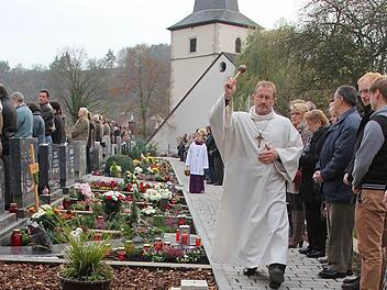Allerheiligen in Ramsthal: Wortgottesdienstleiter Edwin Metzler segnete die Gräber auf dem neu gestalteten Friedhof mit Wasser aus dem Jordan in Israel.  Foto: Gerd Schaar