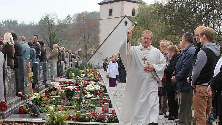 Allerheiligen in Ramsthal: Wortgottesdienstleiter Edwin Metzler segnete die Gräber auf dem neu gestalteten Friedhof mit Wasser aus dem Jordan in Israel.  Foto: Gerd Schaar