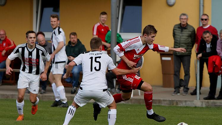 Die Krumer Dustin F&ouml;sel und Andre St&ouml;&szlig;lein (von links) haben enorme M&uuml;he, den G&auml;stest&uuml;rmer Christian Hofgesang auf dem linken Fl&uuml;gel zu bremsen.  Foto: G&uuml;nther Geiling