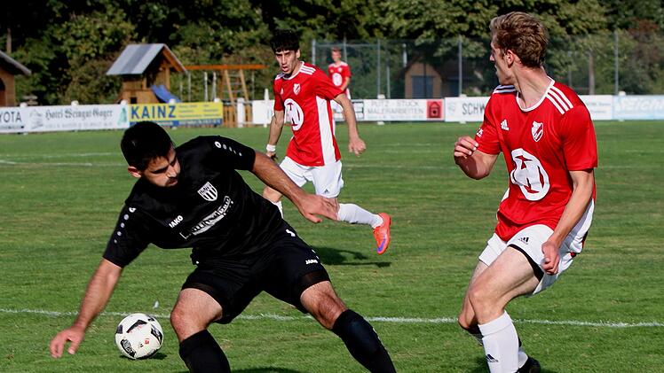 Der Sander Jusuf Kurtanovic (links) kommt gegen den Kissinger Nils Helbig einen Schritt zu sp&auml;t. Im Hintergrund lauert Fuaad Kheder, der die FC-Reserve mit drei Treffern vor gewaltige Probleme stellte.  Foto: G. Geiling