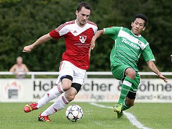 Lukas Pflaum (l.), der den Memmelsdorfer Ausgleichstreffer erzielte, im Zweikampf mit dem Ansbacher Pakorn Silklang. Fotos: sportpress
