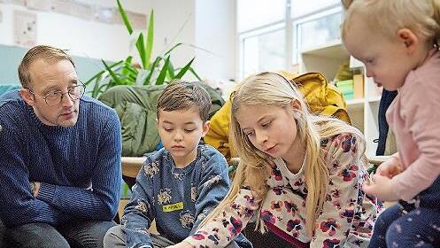 Eine Grundsch&uuml;lerin der L&ouml;wen-Klasse erkl&auml;rt Kindern und Eltern das Montessori-Material.