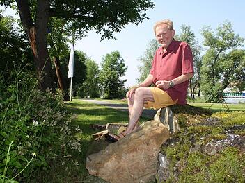 Uwe Zalder zwischen den Gesteinsbrocken, die am Gartenschaugelände darauf warten, bearbeitet zu werden. Foto: Julia Riegler