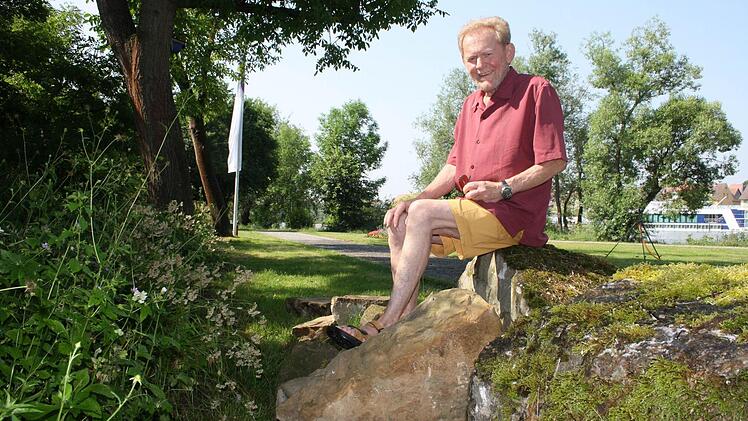 Uwe Zalder zwischen den Gesteinsbrocken, die am Gartenschaugelände darauf warten, bearbeitet zu werden. Foto: Julia Riegler