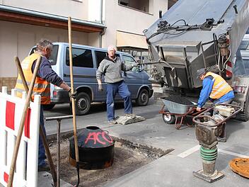 In der Schönbornstraße füllten Arbeiter am Mittwoch mit 150 Grad heißem Bitumen den Ausschnitt um den Kanaldeckel wieder auf. Heute soll die Straße wieder frei sein. Foto:Carmen Schmitt