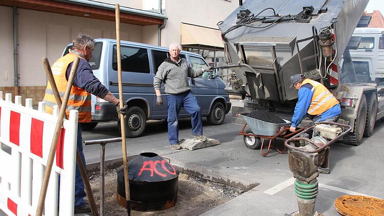 In der Schönbornstraße füllten Arbeiter am Mittwoch mit 150 Grad heißem Bitumen den Ausschnitt um den Kanaldeckel wieder auf. Heute soll die Straße wieder frei sein. Foto:Carmen Schmitt