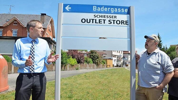 Bürgermeister Marco Steiner und Stadtrat Rolf Wohlleben betrachten das Muster für die neuen Werbeträger, die künftig im Stadtgebiet stehen sollen. Die Beschriftung ist nur ein Gestaltungsmuster.