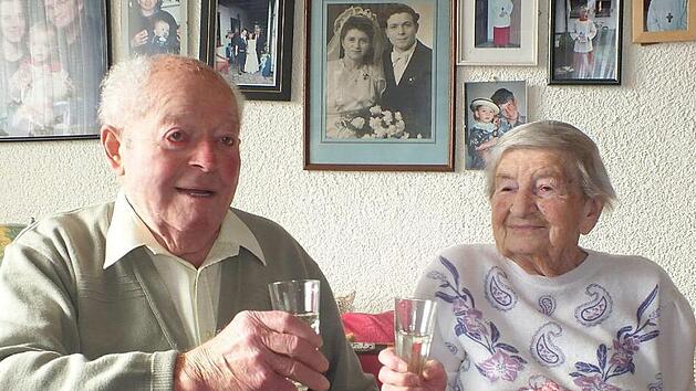 Hans und Erna Mayer beim Ansto&szlig;en auf den Hochzeitstag und vor 70 Jahren (auf dem Bild an der Wand) bei ihrer Hochzeit Foto: Manfred Welker