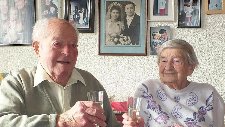 Hans und Erna Mayer beim Anstoßen auf den Hochzeitstag und vor 70 Jahren (auf dem Bild an der Wand) bei ihrer Hochzeit Foto: Manfred Welker