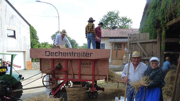Lothar Held und Agnes Brendel in historischen  Dreschgewändern, oben auf der Dreschmaschine Anton Endres Foto: Thomas Weichert