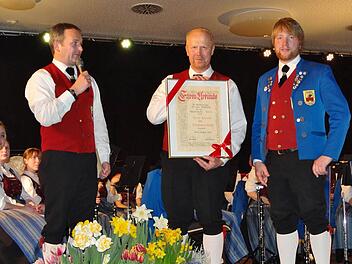 Theo Lerche (Mitte) ist der vierte Ehrenvorsitzende des Blasorchesters Ebern. Musikerkollege Stefan Lurz (links) hielt die Laudatio, Zweiter Vorsitzender Stefan Plott (rechts) überreichte die Ehrenurkunde. Von den Musikern bekam Theo Lerche anhaltenden Beifall. Foto: Johanna Eckert