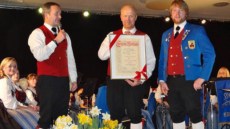 Theo Lerche (Mitte) ist der vierte Ehrenvorsitzende des Blasorchesters Ebern. Musikerkollege Stefan Lurz (links) hielt die Laudatio, Zweiter Vorsitzender Stefan Plott (rechts) überreichte die Ehrenurkunde. Von den Musikern bekam Theo Lerche anhaltenden Beifall. Foto: Johanna Eckert