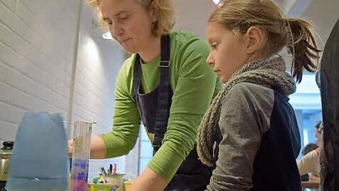Christine Alberth hilft der neunjährigen Lisa beim Eingießen des heißen Paraffins. Foto: Daniela Pondelicek