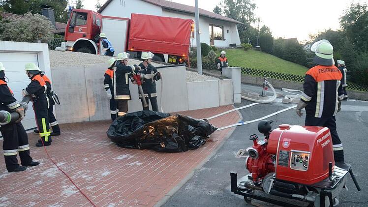 Die FFW Weißenbrunn baut einen 5000-Liter-Faltbehälter auf, der als Zwischenstation zur Wasserbeschaffung dient. Die FFW Thonberg sorgt mit Schlauchmaterial und Pumpe für den Wasseranschluss- und für die Verteilung zum Brandobjekt. Foto: K.-H. Hofmann