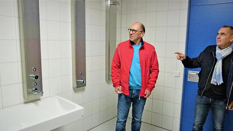 Anfang November soll die Dreifach-Turnhalle für den Schul- und Vereinssport wieder freigegeben werden. Rechtzeitig wurden auch die notwendigen Sanitärinstallationen und Fliesenarbeiten in den Duschräumen zum Abschluss gebracht. Rektor Mathias Liebig (links) und Schulverbandsvorsitzender Alexander Wunderlich überzeugten sich von den Arbeiten.  Foto: Werner Reißaus
