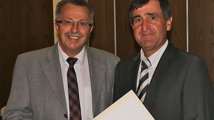 Stellvertretender Landrat Emil Müller (links) überreicht Karl-Heinz Stahl die kommunale Dankesurkunde.