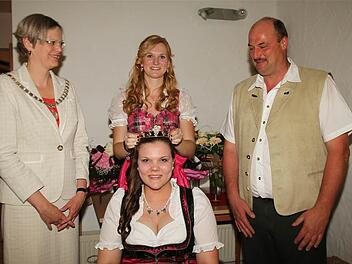 Bürgermeisterin Christine Konrad und Rainer Müller beobachten, wie Mona Wiedermann Julia Müller die Krone der Neuseser Weinprinzessin aufsetzt. Foto: amo