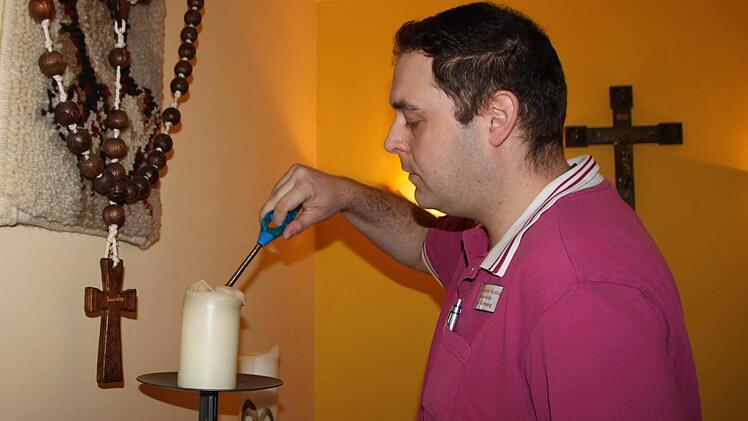 Sozialbetreuer Markus Weller zündet eine Kerze an... Foto: Ulrike Müller