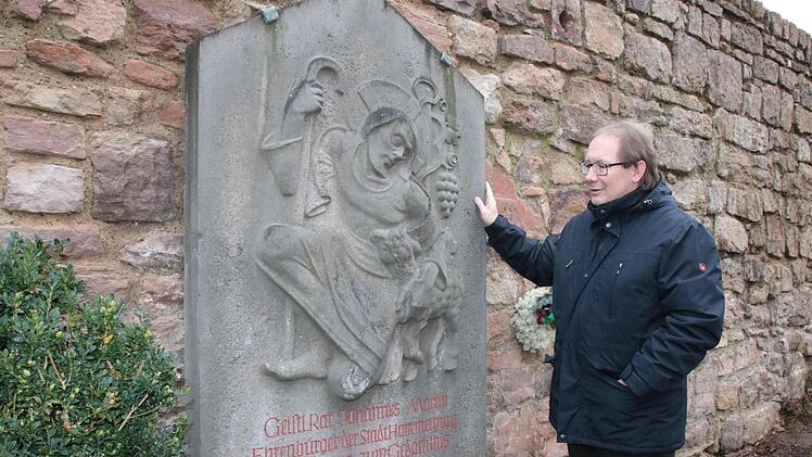 Der heutige Stadtpfarrer Thomas Eschenbacher betrachtet den Gedenkstein für Pfarrer Martin hinter der Stadtpfarrkirche. Foto: Ralf Ruppert