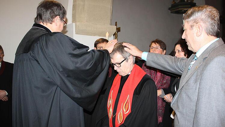 Dekan Martin Ost (l.) und die Mitglieder des Kirchenvorstands entpflichteten Ulrich Bauer-Marks durch Handauflegen von seinen Aufgaben. Foto: Sonja Werner