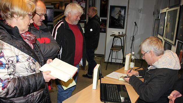 Gefragter Mann: Udo Pörschke beim Signieren seines Buches. "Was aus unseren Kindern alles geworden ist", war eine Mutter, deren Sohn mit Udo während seiner Zeit in Ebern befreundet gewesen war, fasziniert.   Foto: Ralf Kestel
