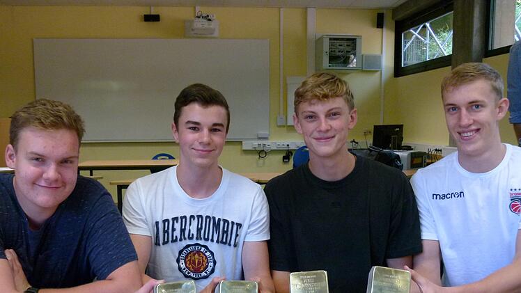 Schüler des KHG zeigen die vier Stolpersteine, die heute für die Familie Reichmannsdorfer in Trabelsdorf verlegt werden.