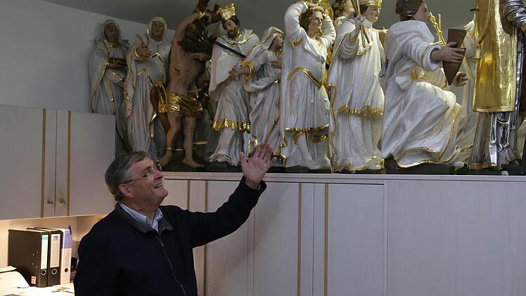 Pfarrer Wolf schaut in der Sakrestei nach den Heiligenfiguren.  Fotos: Franz Galster