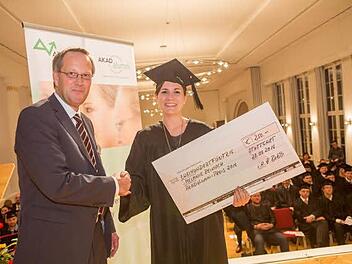 Melanie Reinisch erhält von Prof. Dr. Wolfgang Bohlen von der AKAD University den Preisscheck. Foto: Ina Debald