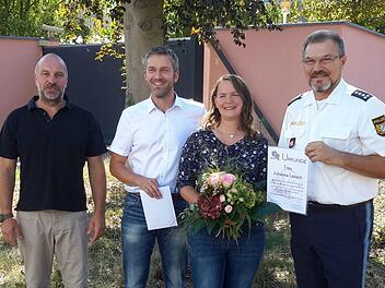 Mit Urkunde und Blumen bedankte sich Bad Brückenaus Polizeichef Herbert Markert (rechts) bei Johanna Leitsch. Auch der Ermittlungsbeamte Steffen Trabert (links) und Mottens Bürgermeister Jochen Vogel (2.v.l.) lobten das besonnene Vorgehen der 33-jährigen Bäckermeisterin aus Speicherz. Foto: Rolf Pralle