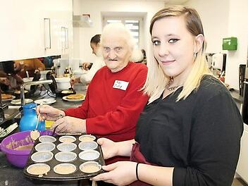Maria Zillig (links) und Michelle Koch f&uuml;llen den Muffin-Teig in die F&ouml;rmchen.  Foto: Johanna Ott/Mehrgenerationenhaus