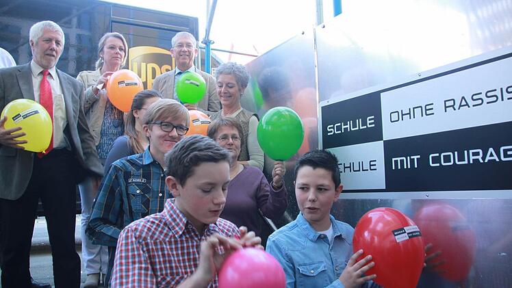 Die Schulleiter Bernd Lohneiß (Gymnasium, hinten links) und Michael Ulbrich (Mittelschule, hinten rechts) zeigen gemeinsam mit den Organisatorinnen Sonja Größler (hinten Mitte) und Petra Arnold (rechts in der zweiten Reihe von hinten) und weiteren Lehrerinnen und Schülern die Ballons für den Flashmob.Foto: Maria Leicht