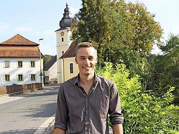 Der evangelische Vikar Simon Meyer vor der evangelischen Pfarrkirche in Pommersfelden  Foto: Evi Seeger