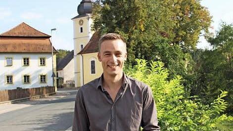 Der evangelische Vikar Simon Meyer vor der evangelischen Pfarrkirche in Pommersfelden  Foto: Evi Seeger