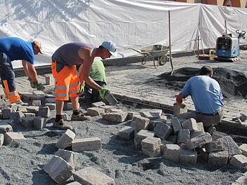 Stein an Stein reiht sich das neue Pflaster schon weit in die Baustelle hinein. Die Bauarbeiter kommen zügig voran, was vor allem die Einzelhändler und ihre Kunden freut. Fotos: Marco Meißner