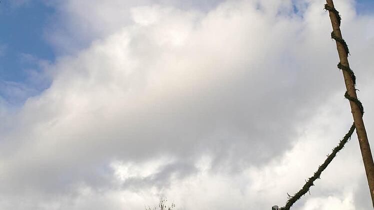 Steffen Kraus und Patrick Oberhauser wickeln die letzte Girlande um den Kirmesbaum.