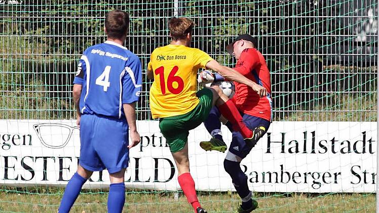 Mit einer waghalsigen Aktion rettet der Stegauracher Torwart Stefan Mühlfriedel gegen den DJKler Markus Schnitzer; Christian Ott (vorne) beobachtet die Szene. Fotos: sportpress